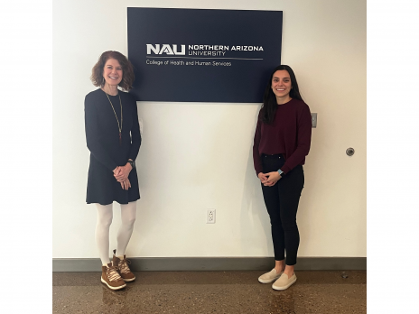Dr. Pamela Bosch and Lizze pose at an NAU sign