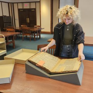 Alex Williams looking at a large book.