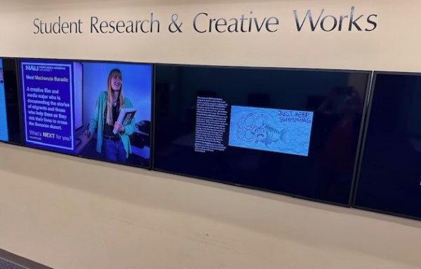 Four display monitors on a wall below the words Student Research & Creative Works