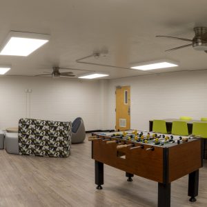 allen game room and kitchen with students playing foozball