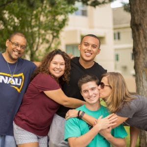 Diverse family group hugging during move in day