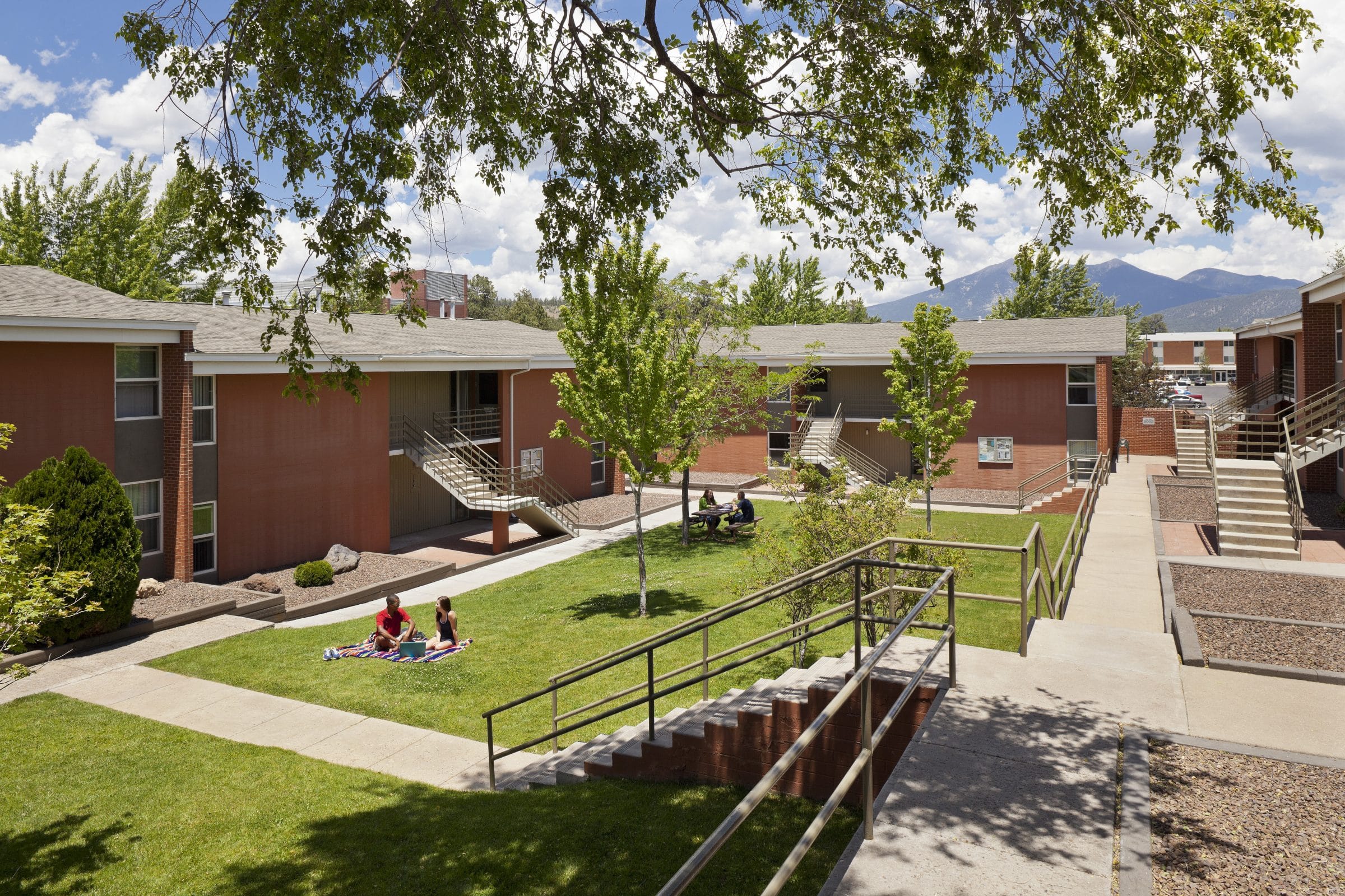 Picture of campus heights courtyard with two people having a picnic on the grass