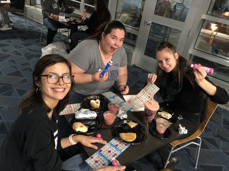 Three females at the late night breakfast playing bingo while eating breakfast