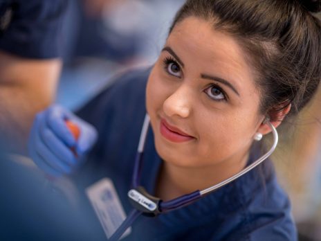NAU Nursing student with a stethoscope in her ears to hear a heartbeat.