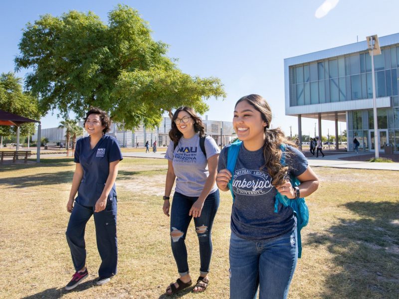 Students on campus walking on a field.