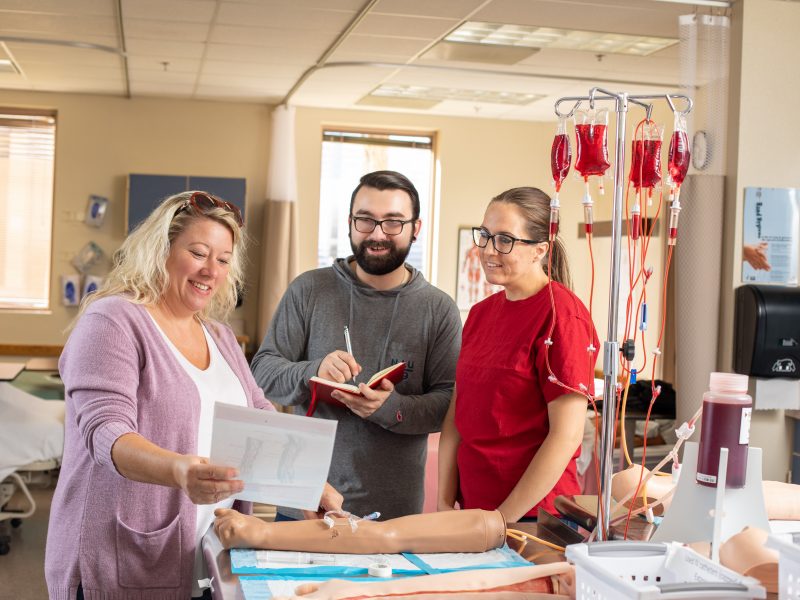 Nursing students observing sheet in a learning environment.