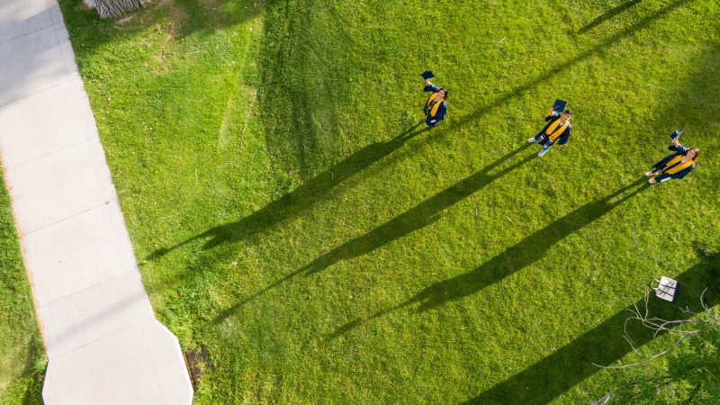 Graduating students looking to an aerial shot.