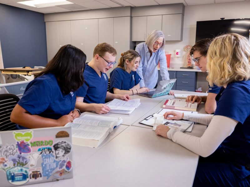 Photos of students attending class and working as part of the School of Nursing.