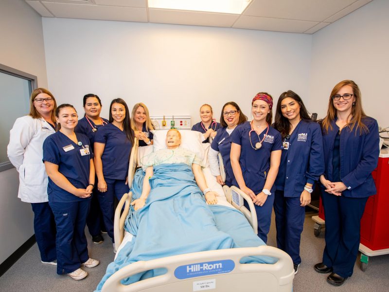 A nursing class at N A U Yuma poses with a mannequin.