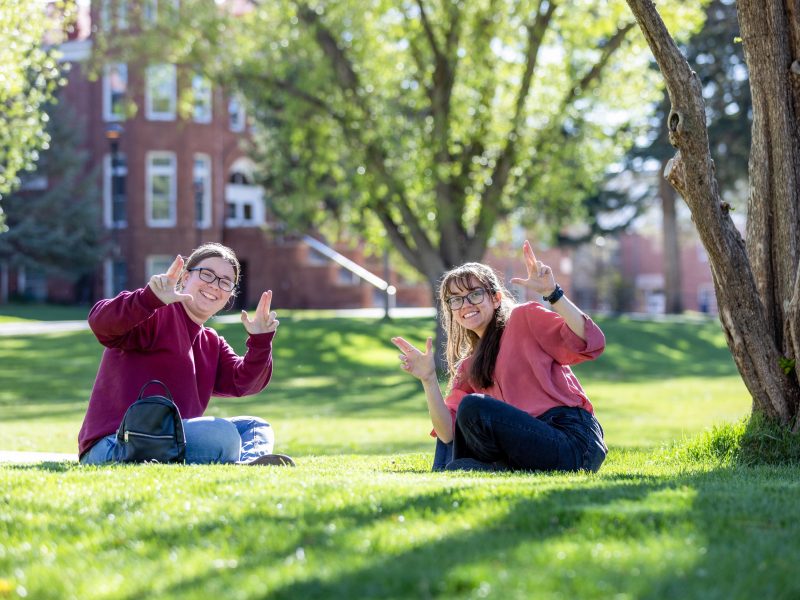 Students smile while doing the "Lumberjacks" hand symbol.