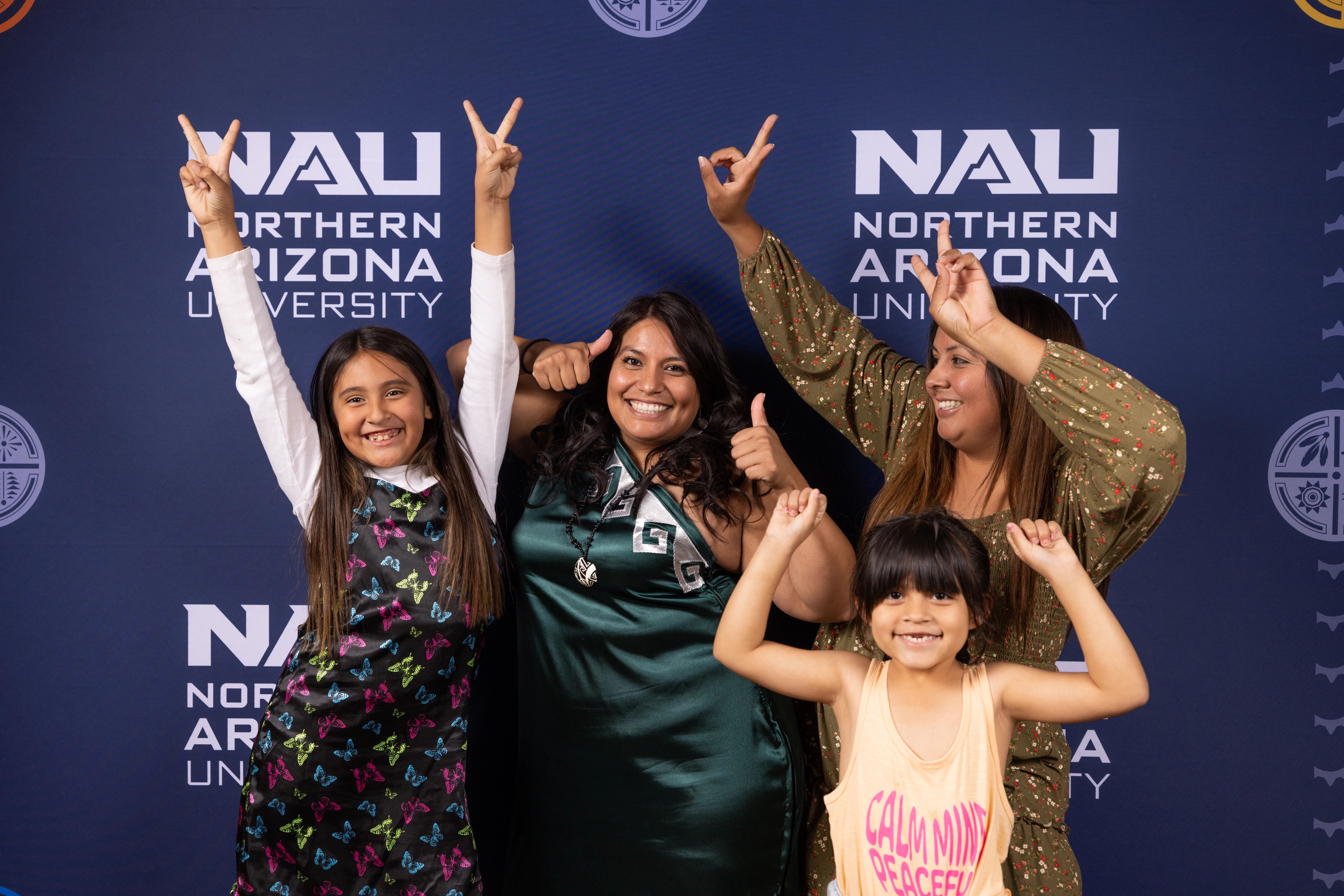 A family smiles and poses at N A U's indigenous convocation.