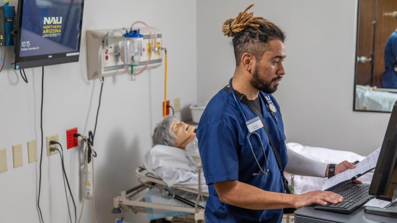 A nursing student at N A U trains on a mannequin.