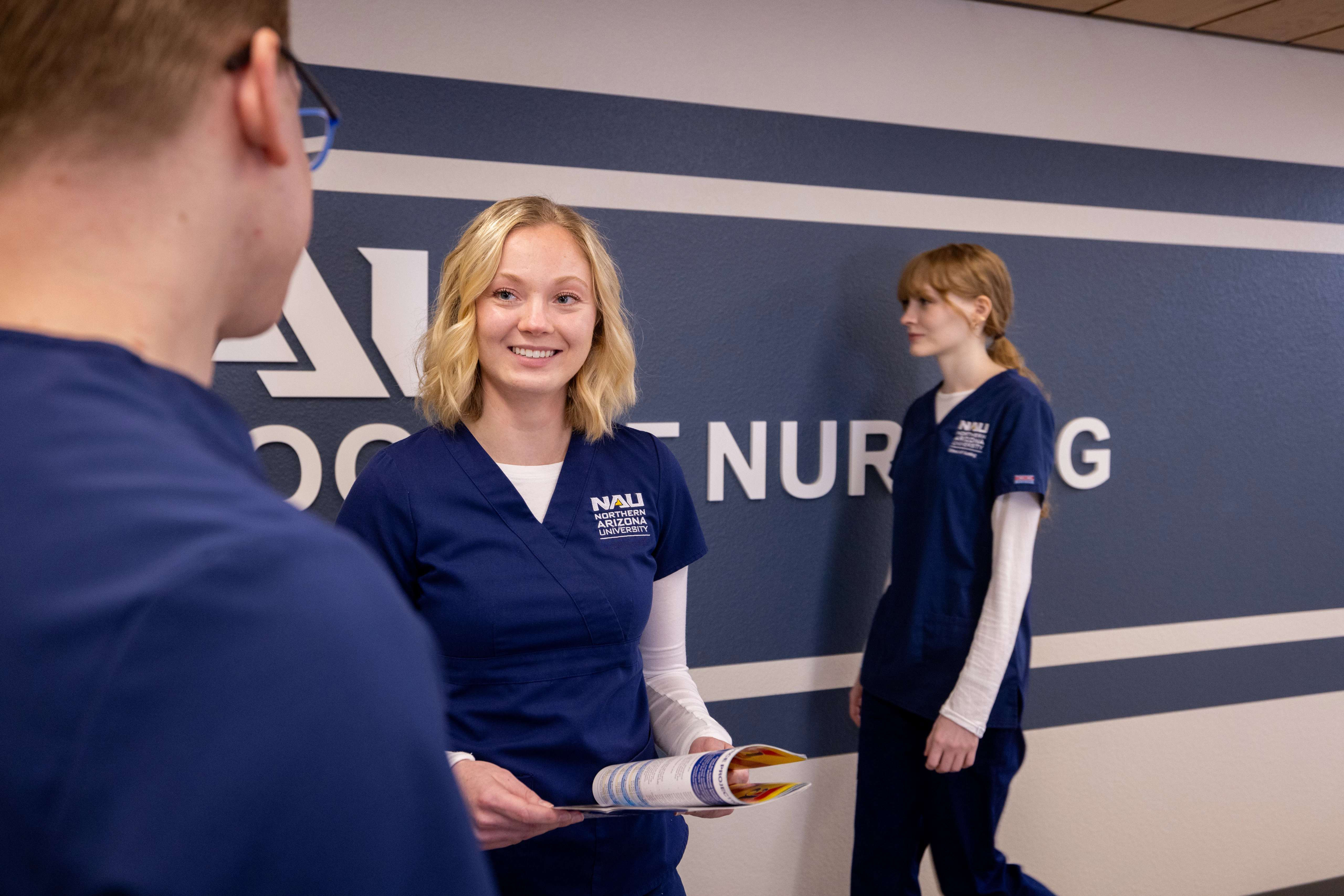 N A U Nursing students talk in the hallway between classes.