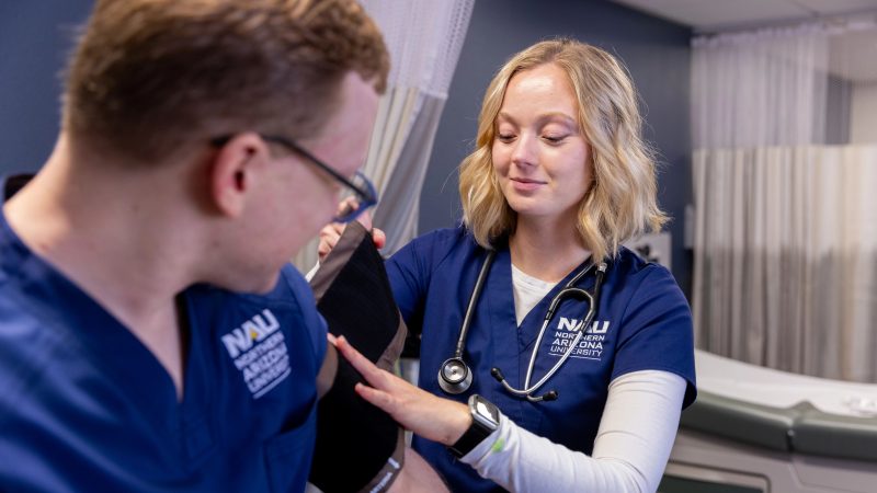 N A U Nursing students practice taking each other's vitals.