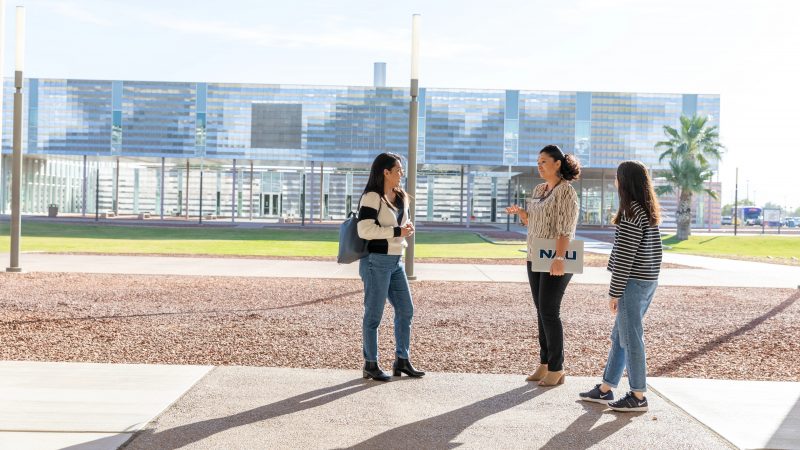 N A U–Yuma students chat with an advisor on campus.