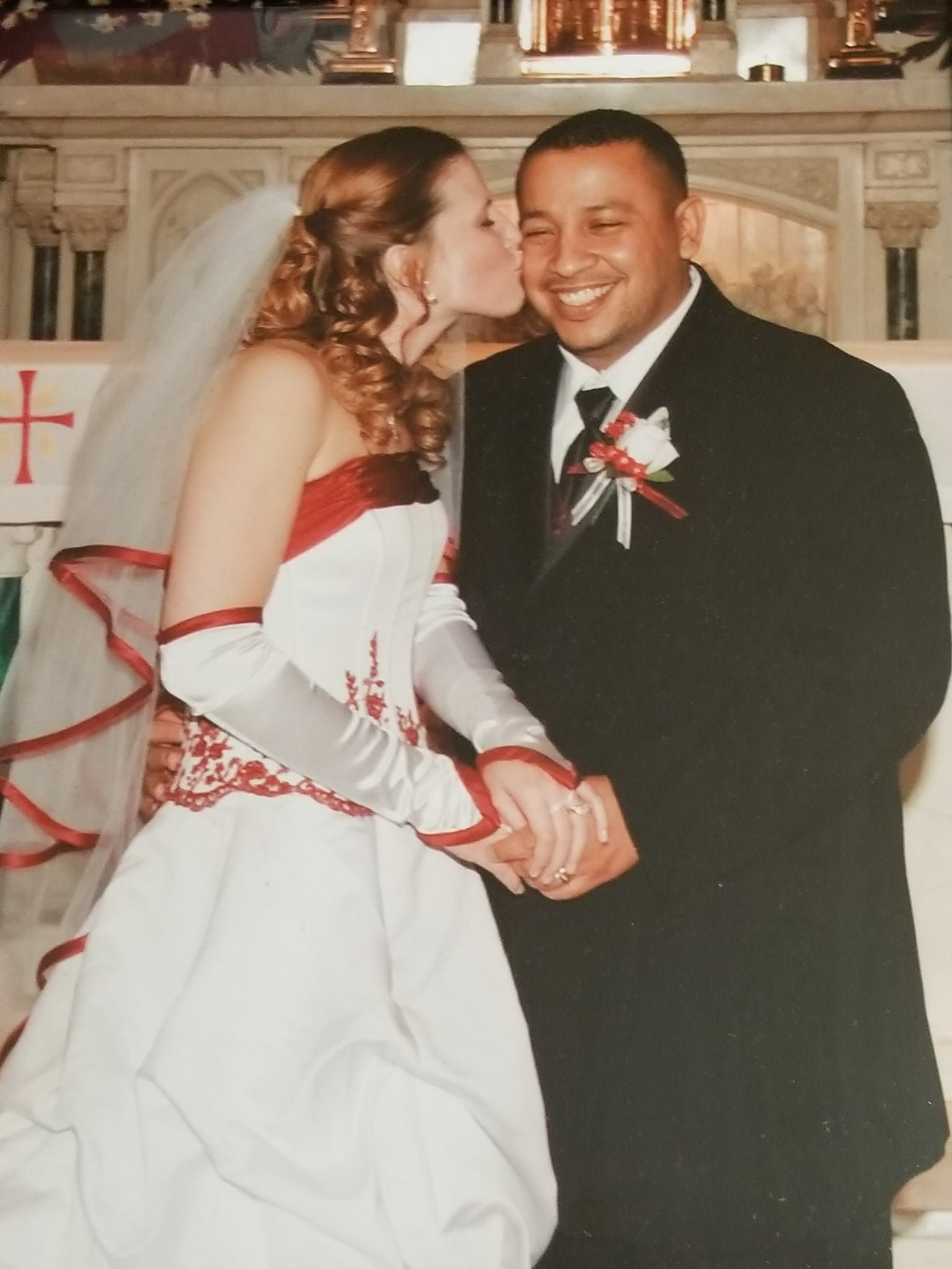 Couple getting married, wife kissing husband on the cheek.