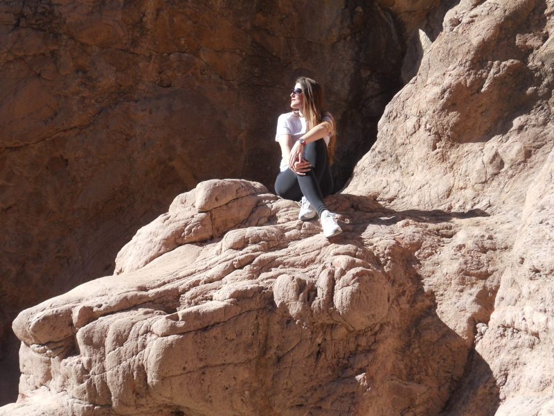 Associate Dean Misty Pagan is sitting on a rock.