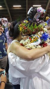 Jeanine embracing an important women in her life, wearing graduation regalia