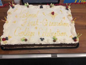 White sheet cake with "National First-Generation College Celebration" written on it in yellow frosting