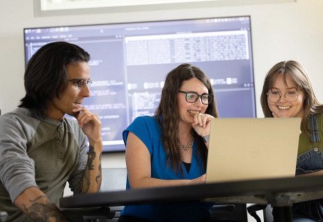 Three computer scientist looking at computer screen 