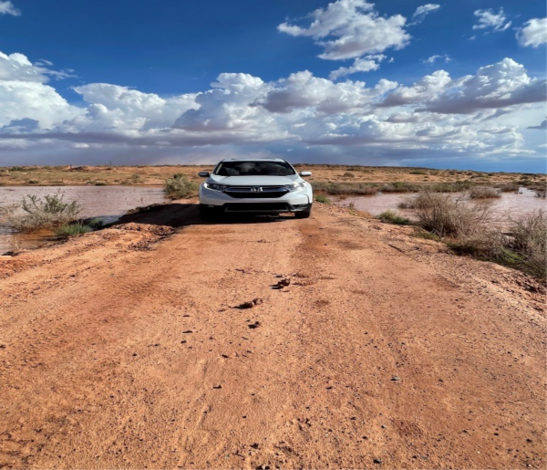 NAU car drives on a muddy road while reserachers visit homes on the Navajo Nation[