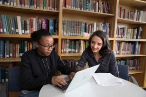 Two students collaborating on a computer.