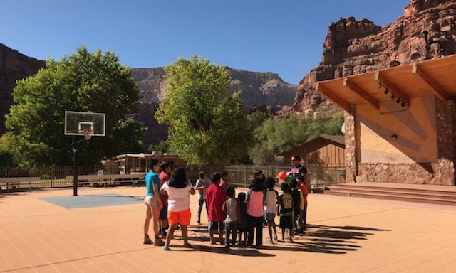 An image of Amanda Hunter engaging with Supai youth in an activity outdoors.