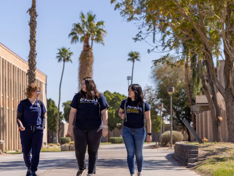 Three individuals walking on campus