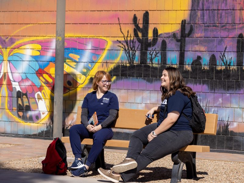 NAU–Yuma students sitting in front of mural