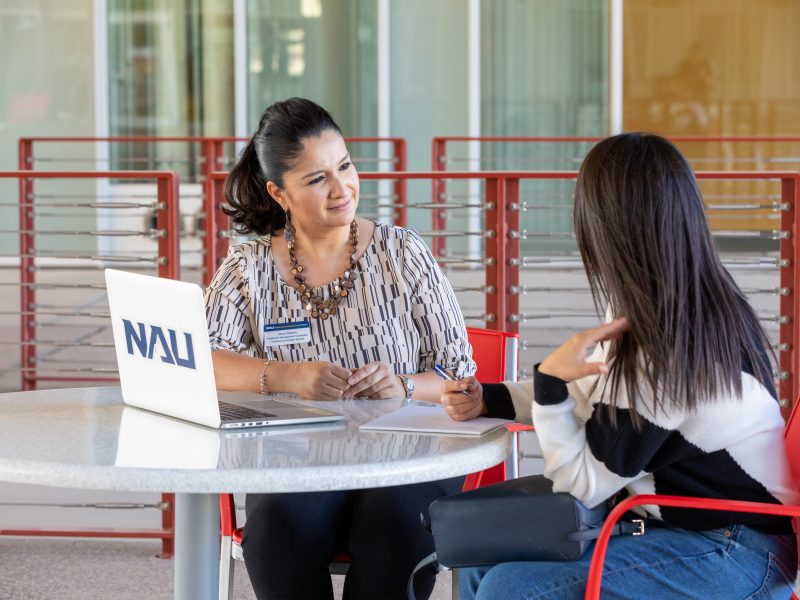 An NAU–Yuma advisor working with a student outside