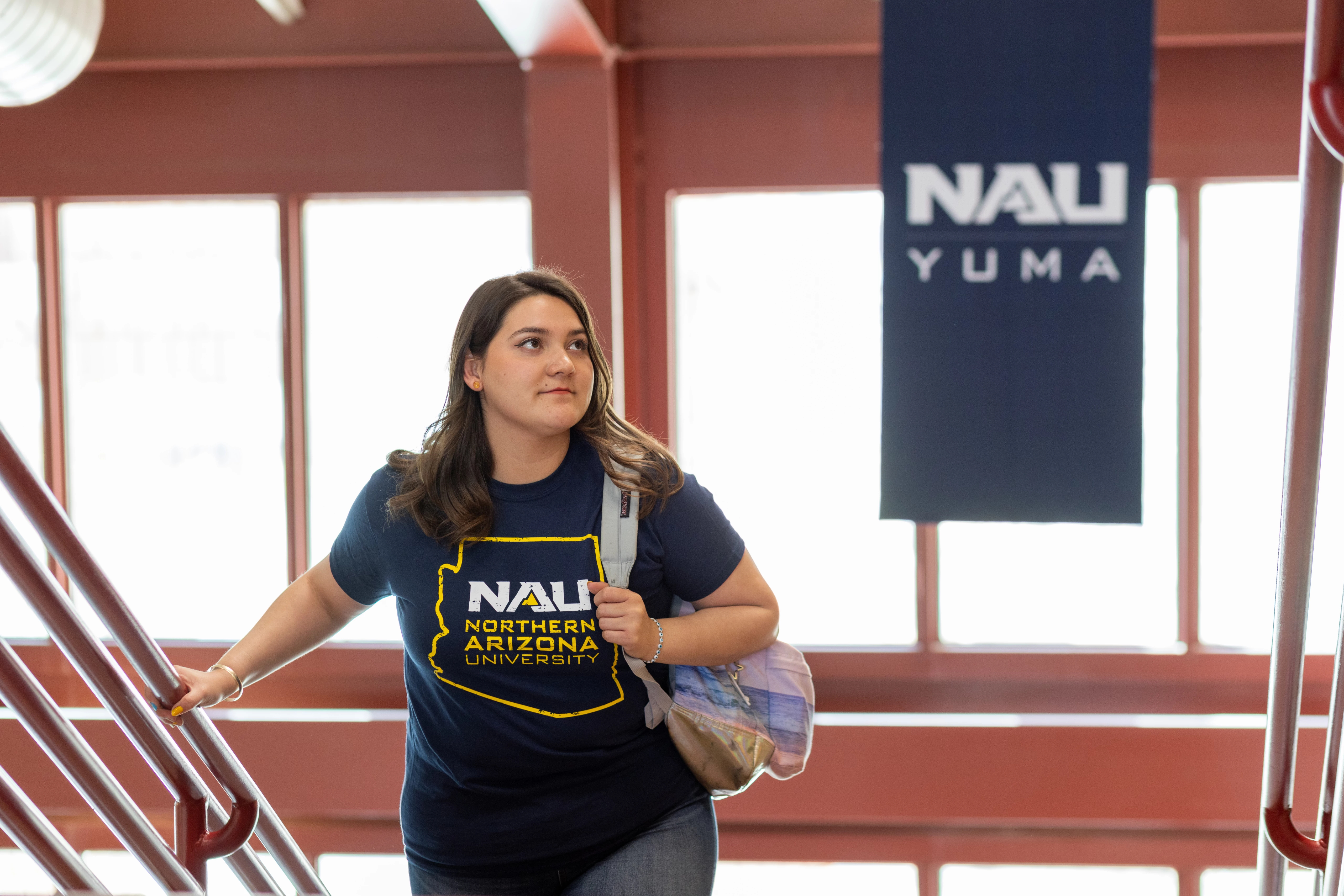 Student walking up a staircase at NAU–Yuma